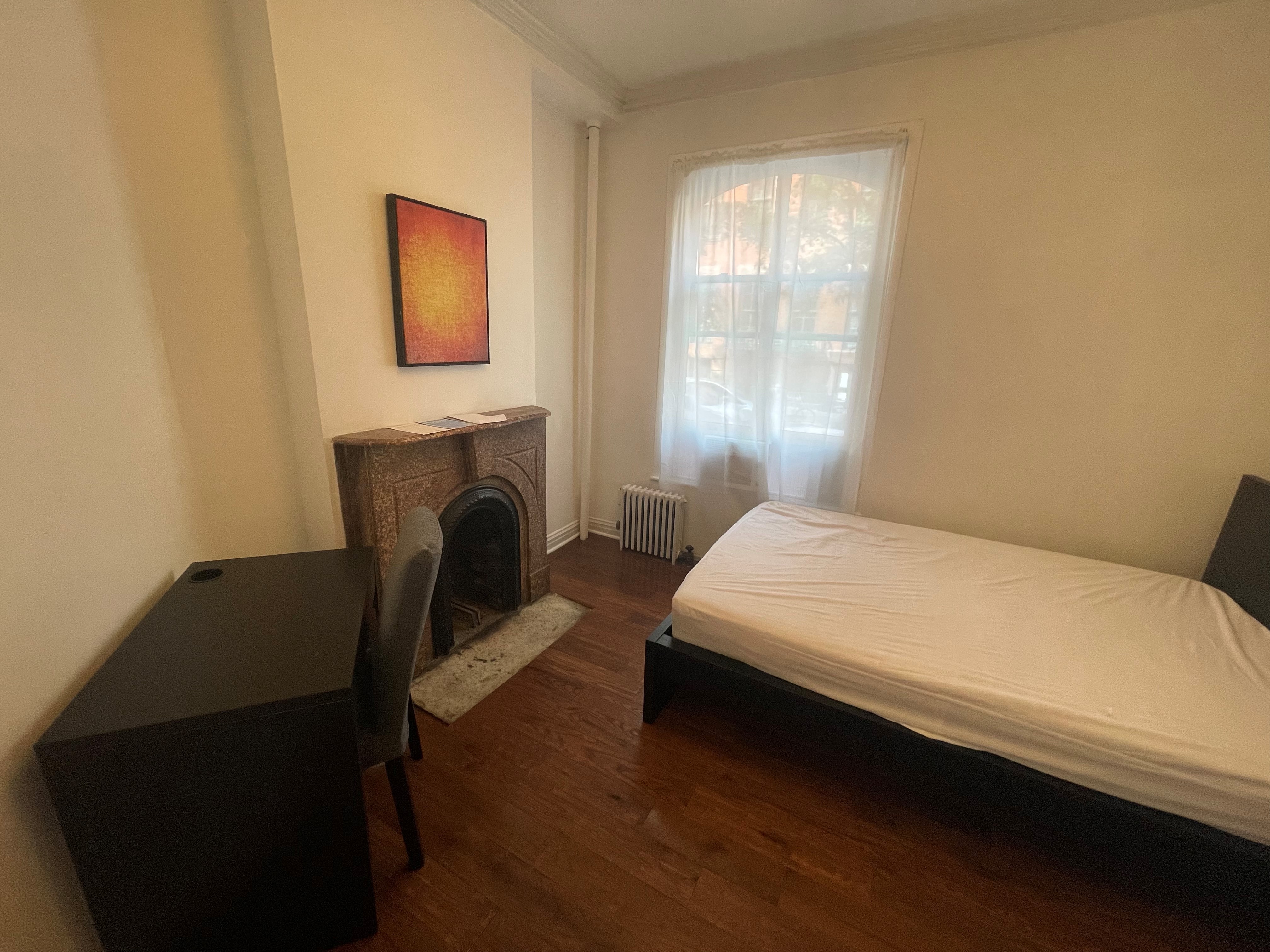 120 East 10th Street, Unit 1 Manhattan, NY 10003 - Photo 8 of 24 a bedroom with a bed chair and a fireplace