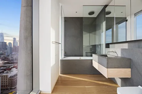 a living room with stainless steel appliances kitchen island granite countertop a refrigerator and a sink