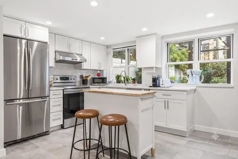 a kitchen with stainless steel appliances a refrigerator sink and cabinets