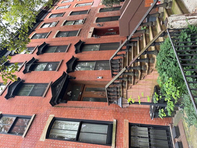 a front view of a residential apartment building with a yard