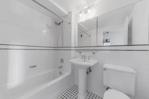 a bathroom with a sink a toilet a mirror and shower