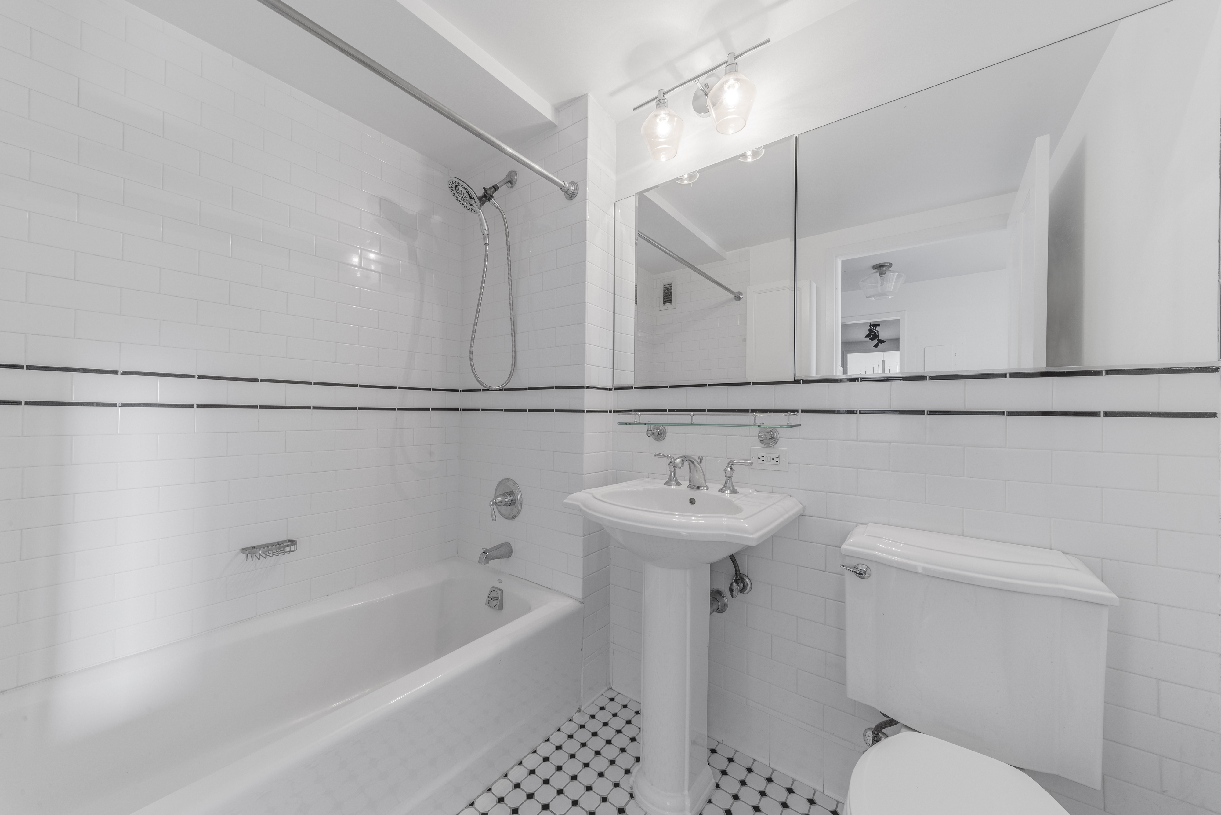 300 West 135th Street, Unit 12C Manhattan, NY 10030 - Photo 5 of 9 a bathroom with a sink a toilet a mirror and shower
