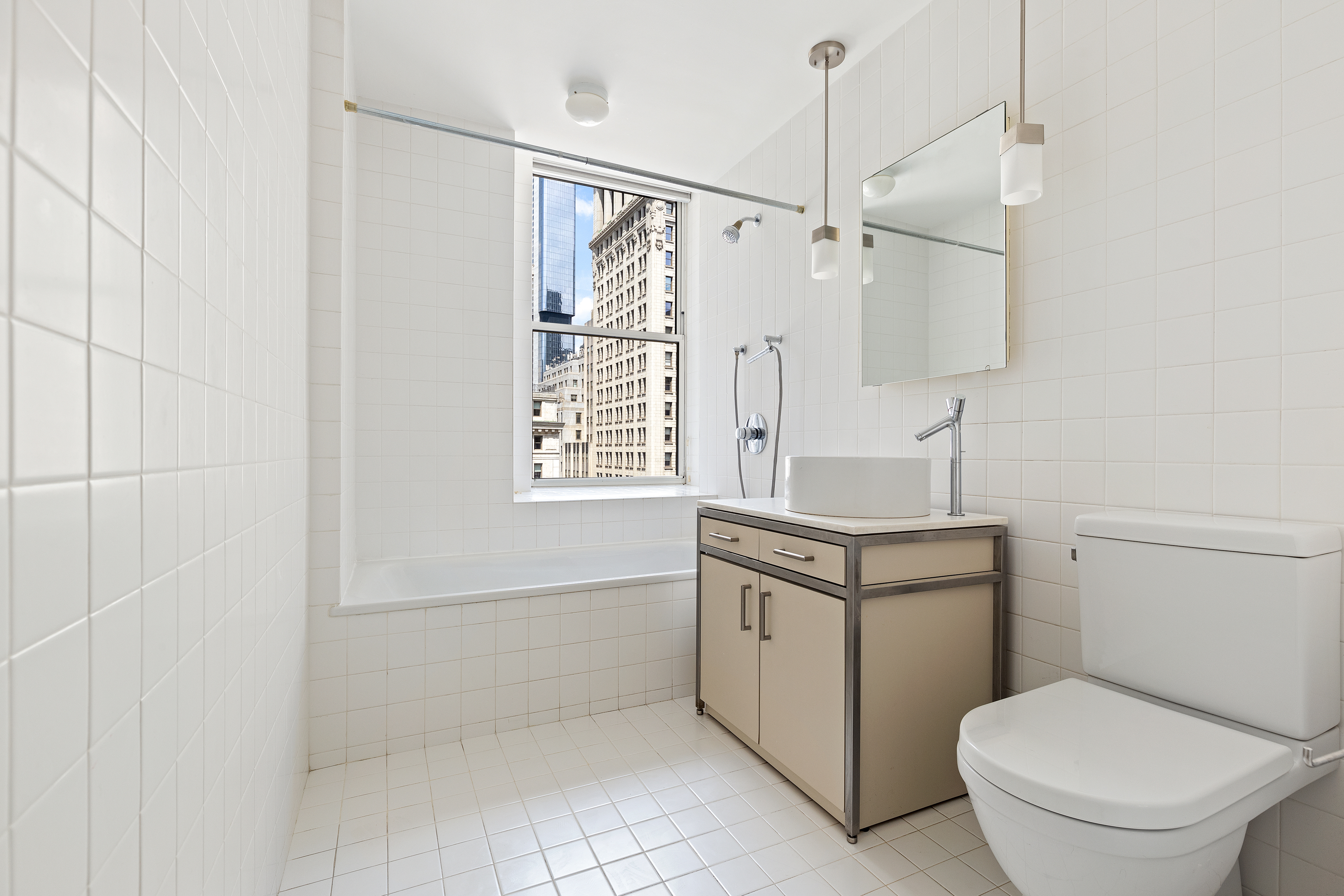 15 Broad Street, Unit 2000 Manhattan, NY 10005 - Photo 5 of 6 a bathroom with a sink a toilet and shower
