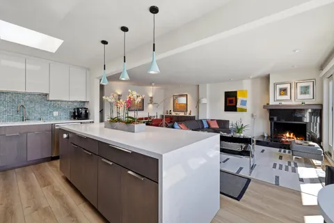 a view of a patio with couches chairs potted plants and wooden floor