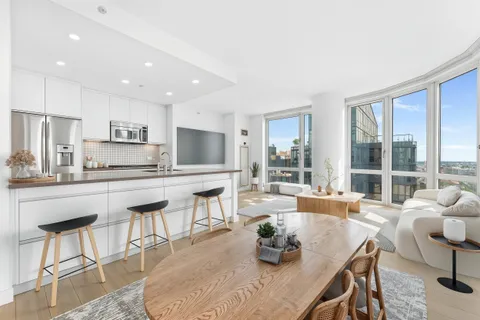 a kitchen with stainless steel appliances granite countertop a stove a sink a dining table and chairs