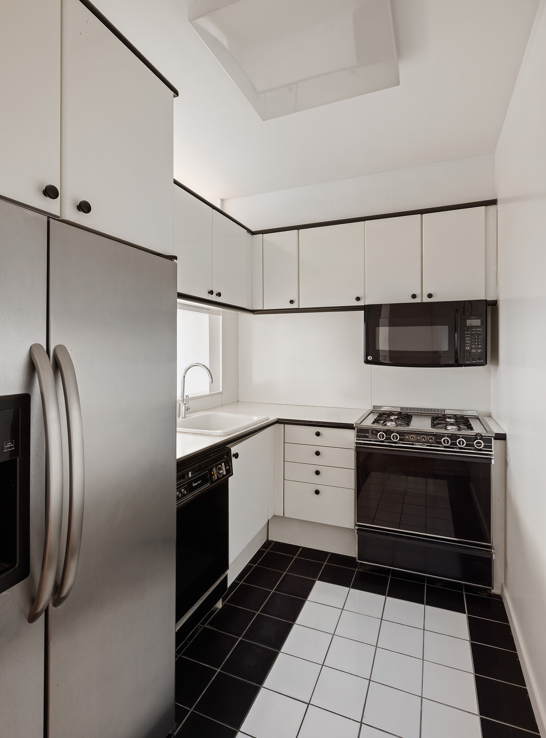 150 West 56th Street, Unit 6205 Manhattan, NY 10019 - Photo 3 of 6 a kitchen with stainless steel appliances granite countertop a stove and a refrigerator