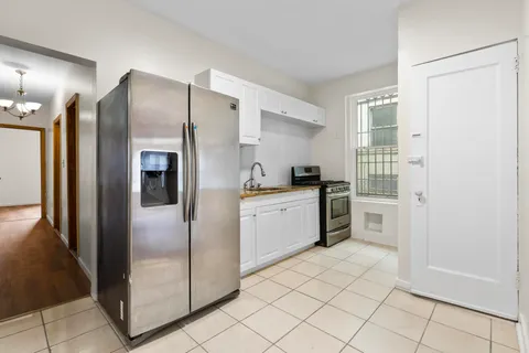 a kitchen with a refrigerator and white cabinets