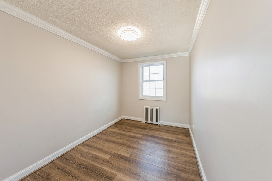 224-46 Horace Harding Expressway, Unit 630 Queens, NY 11364 - Photo 9 of 29 a view of empty room with wooden floor and fan