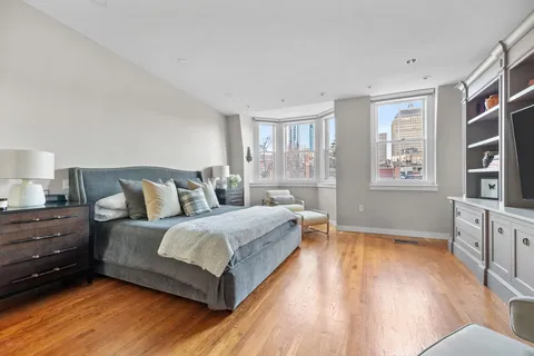 a spacious bedroom with a bed and a flat screen television