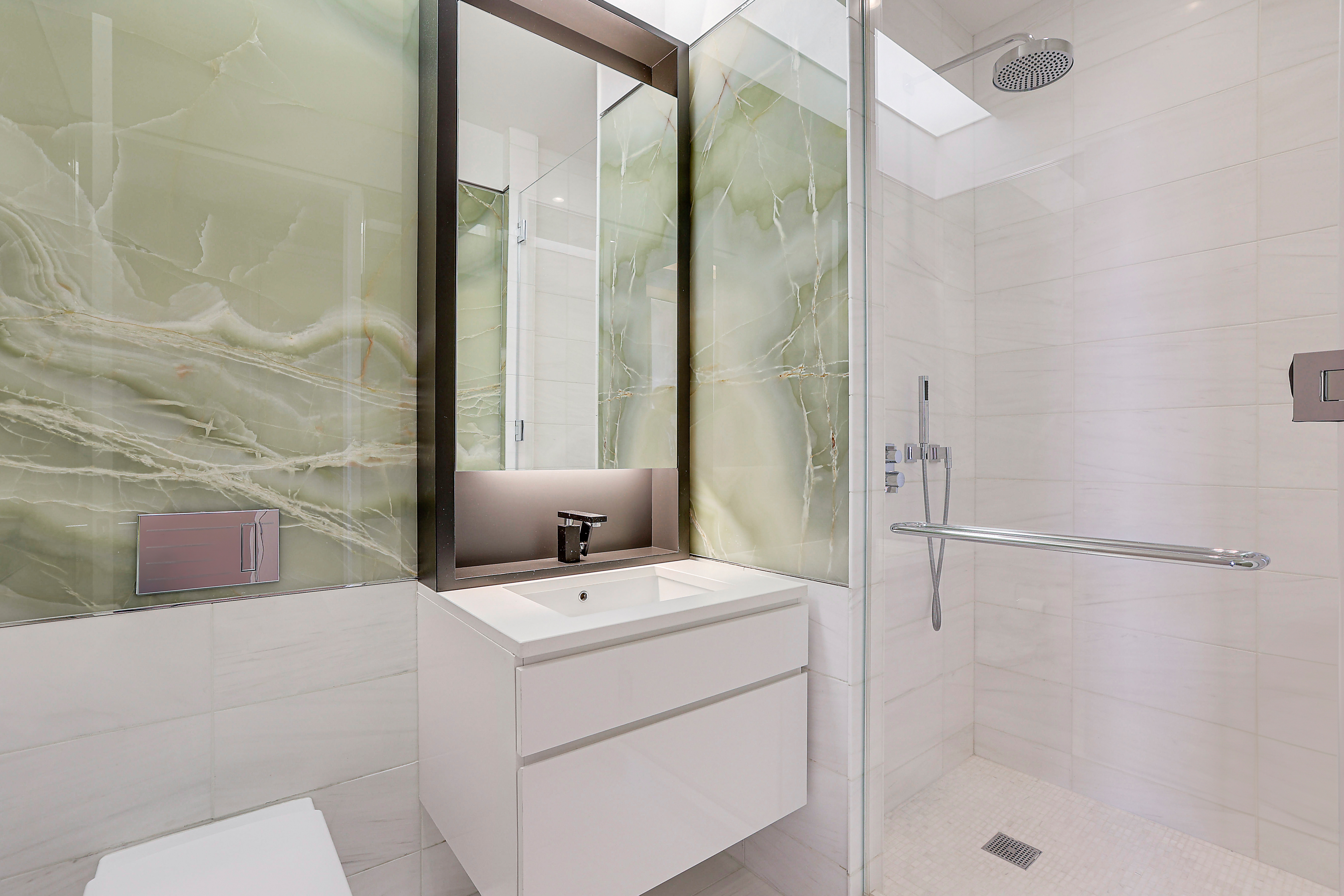 157 West 57th Street, Unit 51A Manhattan, NY 10019 - Photo 9 of 15 a bathroom with a sink a toilet and a shower