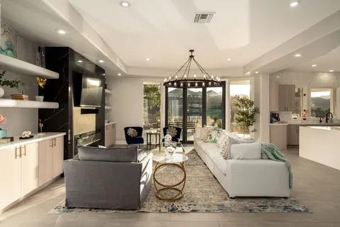 a living room with furniture a floor to ceiling window and a flat screen tv