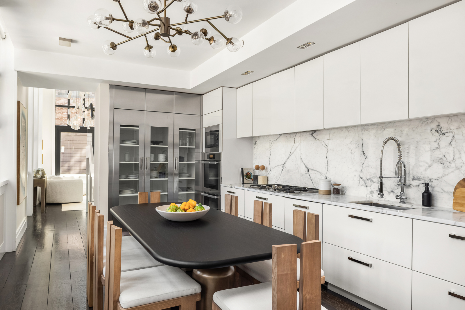 137 Franklin Street, Unit 1 Manhattan, NY 10013 - Photo 7 of 25 a kitchen with stainless steel appliances granite countertop a sink a stove and chairs with wooden floor