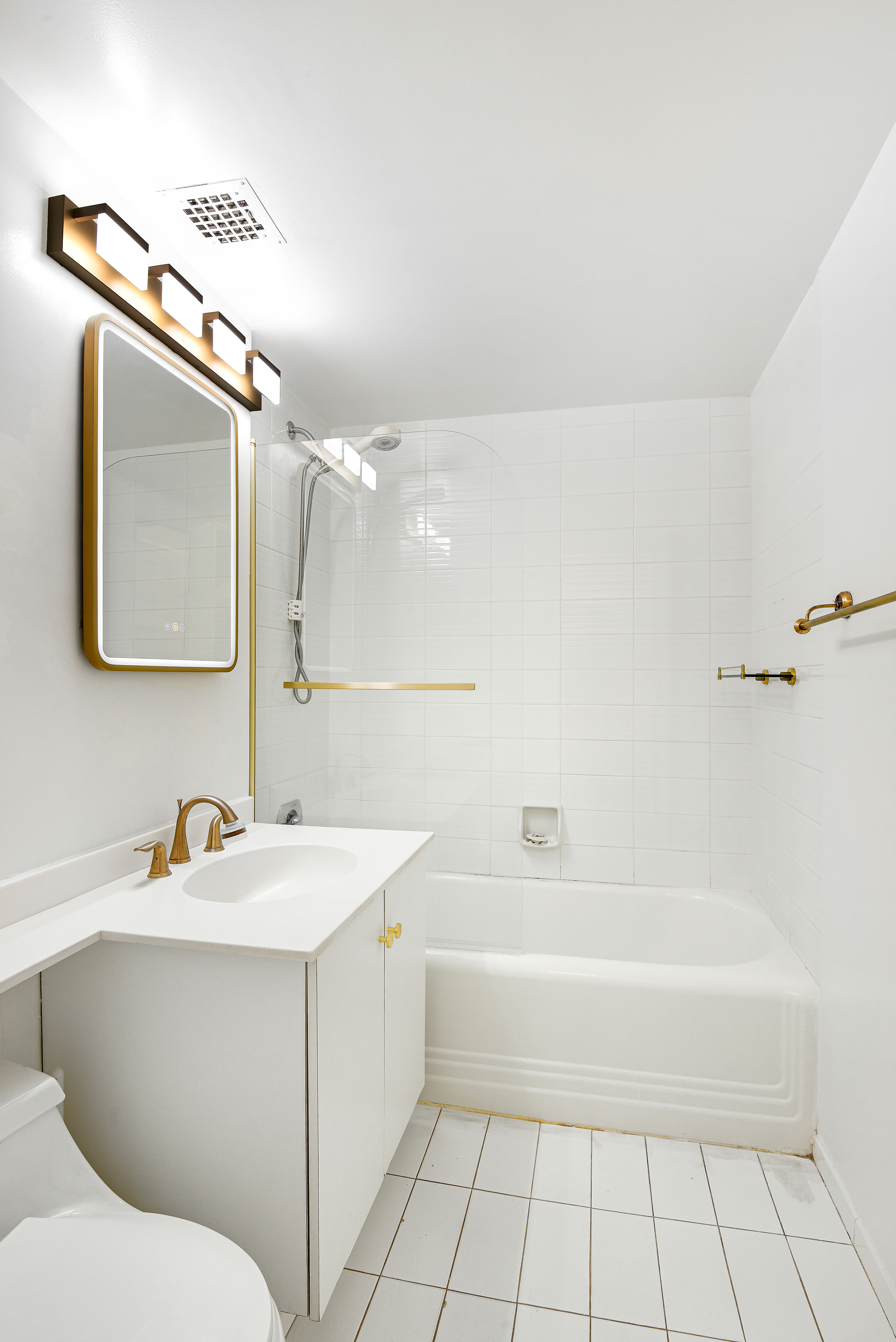 333 West 56th Street, Unit 3H Manhattan, NY 10019 - Photo 5 of 7 a bathroom with a bathtub sink vanity and mirror