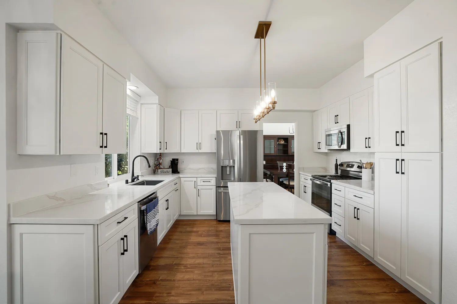 a kitchen with white cabinets and stainless steel appliances