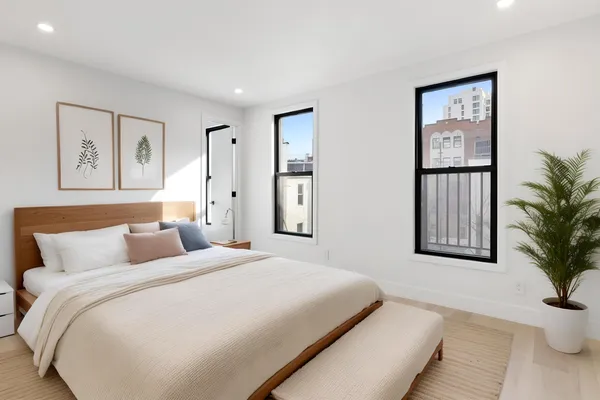 a bedroom with a large bed and a potted plant