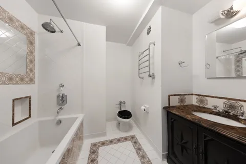 a bathroom with a granite countertop sink a toilet and shower
