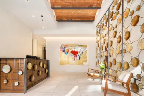a view of a hallway with wooden floor and furniture