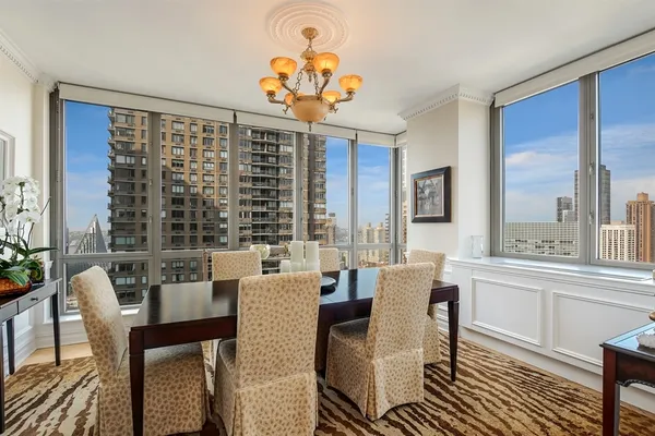 a dining room with furniture a chandelier and wooden floor