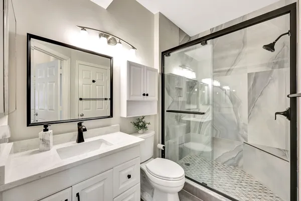 a bathroom with a sink vanity granite toilet and shower