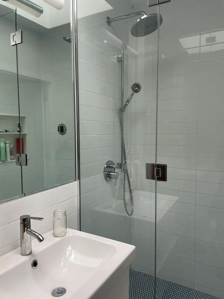 a bathroom with a sink a mirror and shower