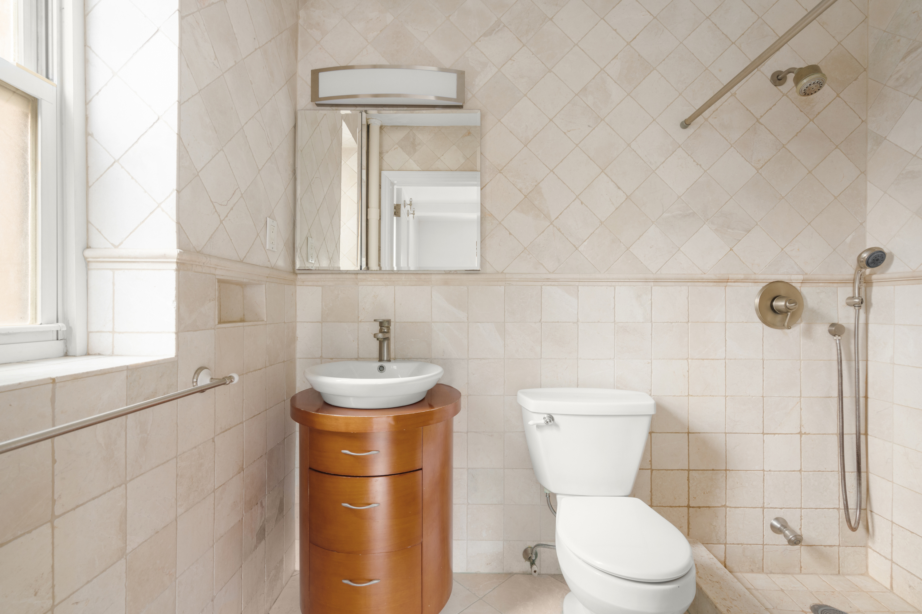 227 East 57th Street, Unit 3DEF Manhattan, NY 10022 - Photo 8 of 13 a bathroom with a toilet sink and mirror