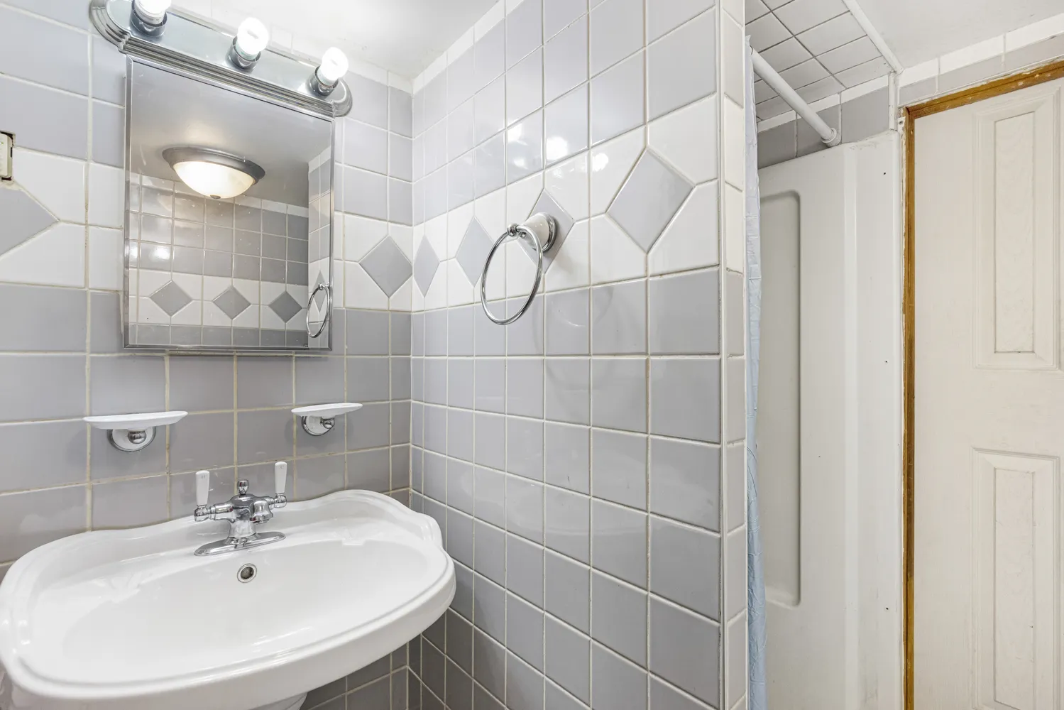 a bathroom with a sink shower and a mirror