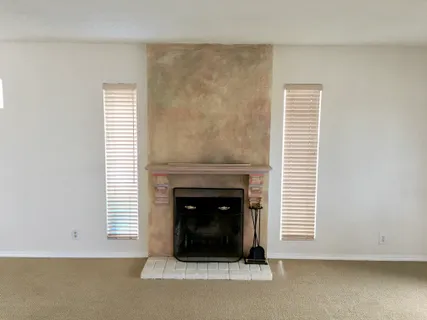 a living room with a fireplace and a window