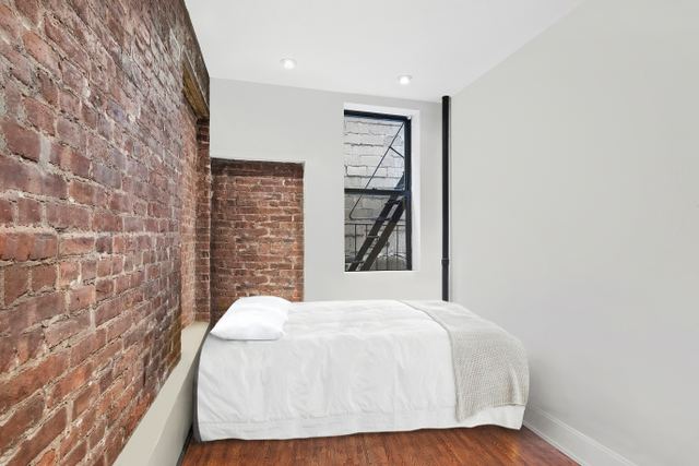 1773 1st Avenue, Unit 1 Manhattan, NY 10128 - Photo 3 of 8 a bedroom with a bed and a wall painting