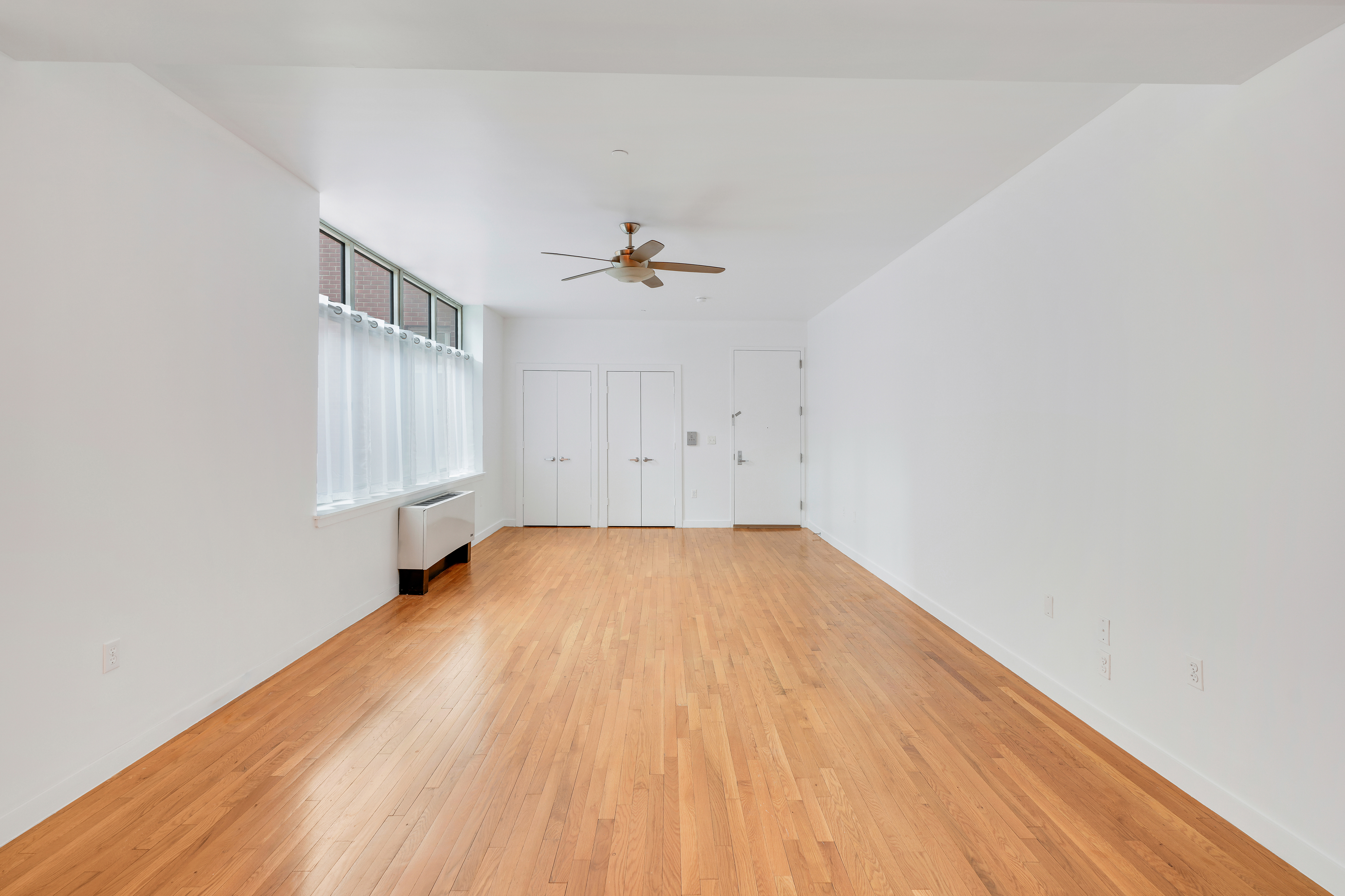 258 St Nicholas Avenue, Unit 3F Manhattan, NY 10027 - Photo 6 of 15 an empty room with a hardwood and a ceiling fan