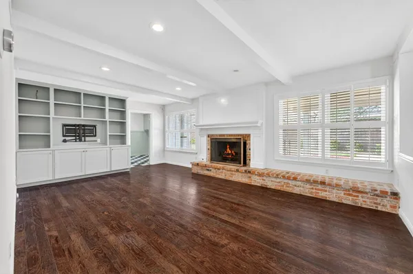 an empty room with wooden floor and fireplace