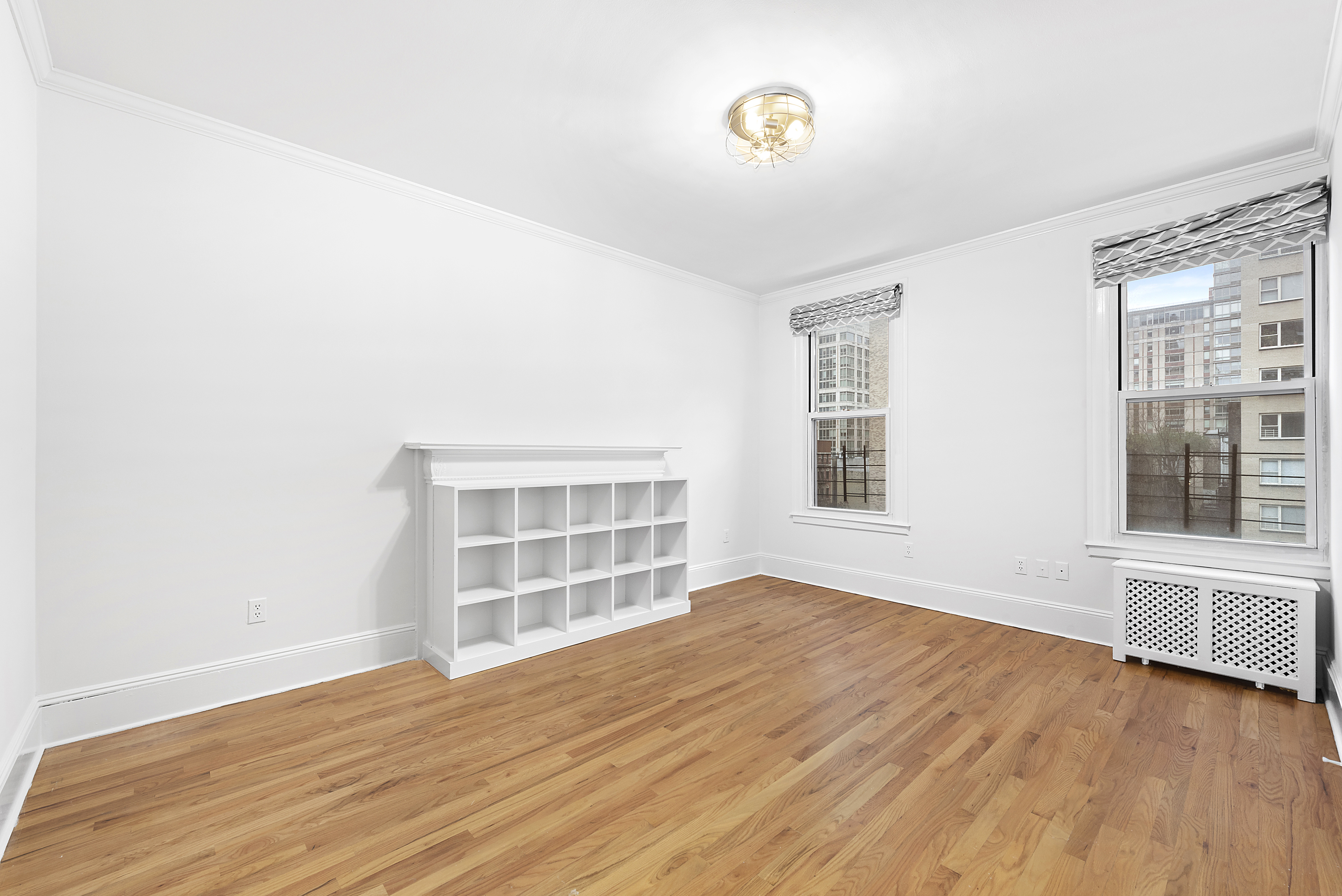 1240 Park Avenue, Unit 4D Manhattan, NY 10128 - Photo 3 of 9 an empty room with wooden floor and windows