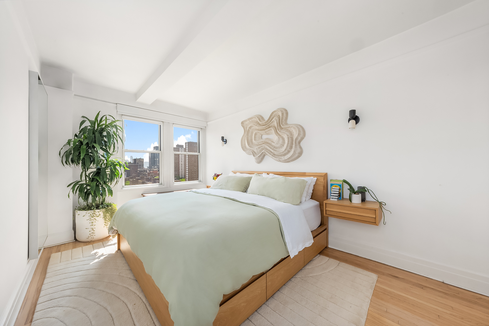 365 West 20th Street, Unit 14B Manhattan, NY 10011 - Photo 12 of 21 a bed room with a bed and a potted plant