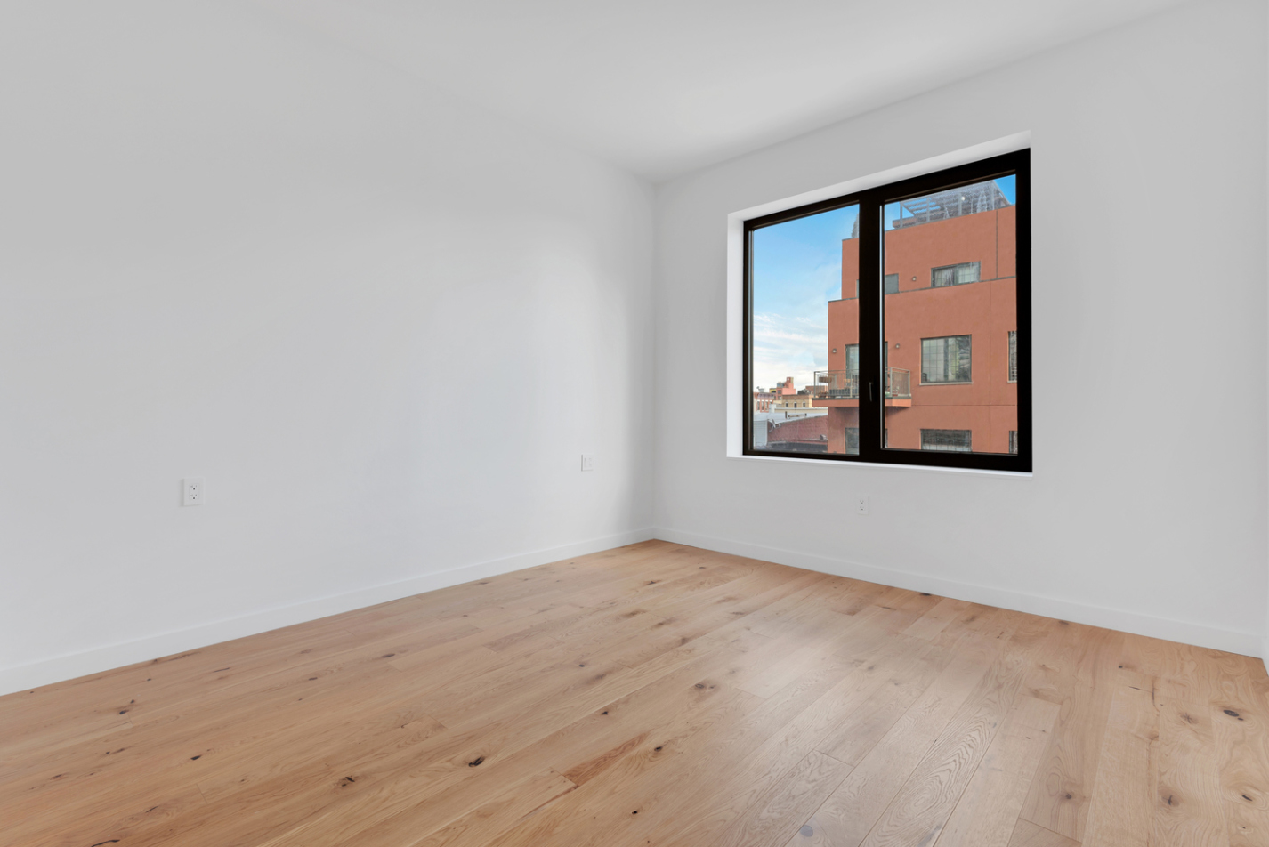 888 Lorimer Street, Unit 4 Brooklyn, NY 11222 - Photo 9 of 13 an empty room with wooden floor and a window