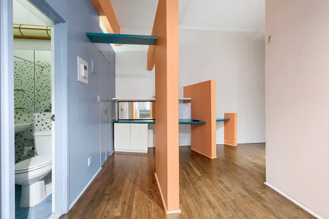 a view of a hallway with wooden floor and a room