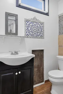 a bathroom with a sink a toilet and mirror