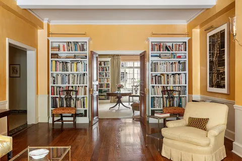 a living room with furniture and a book shelf