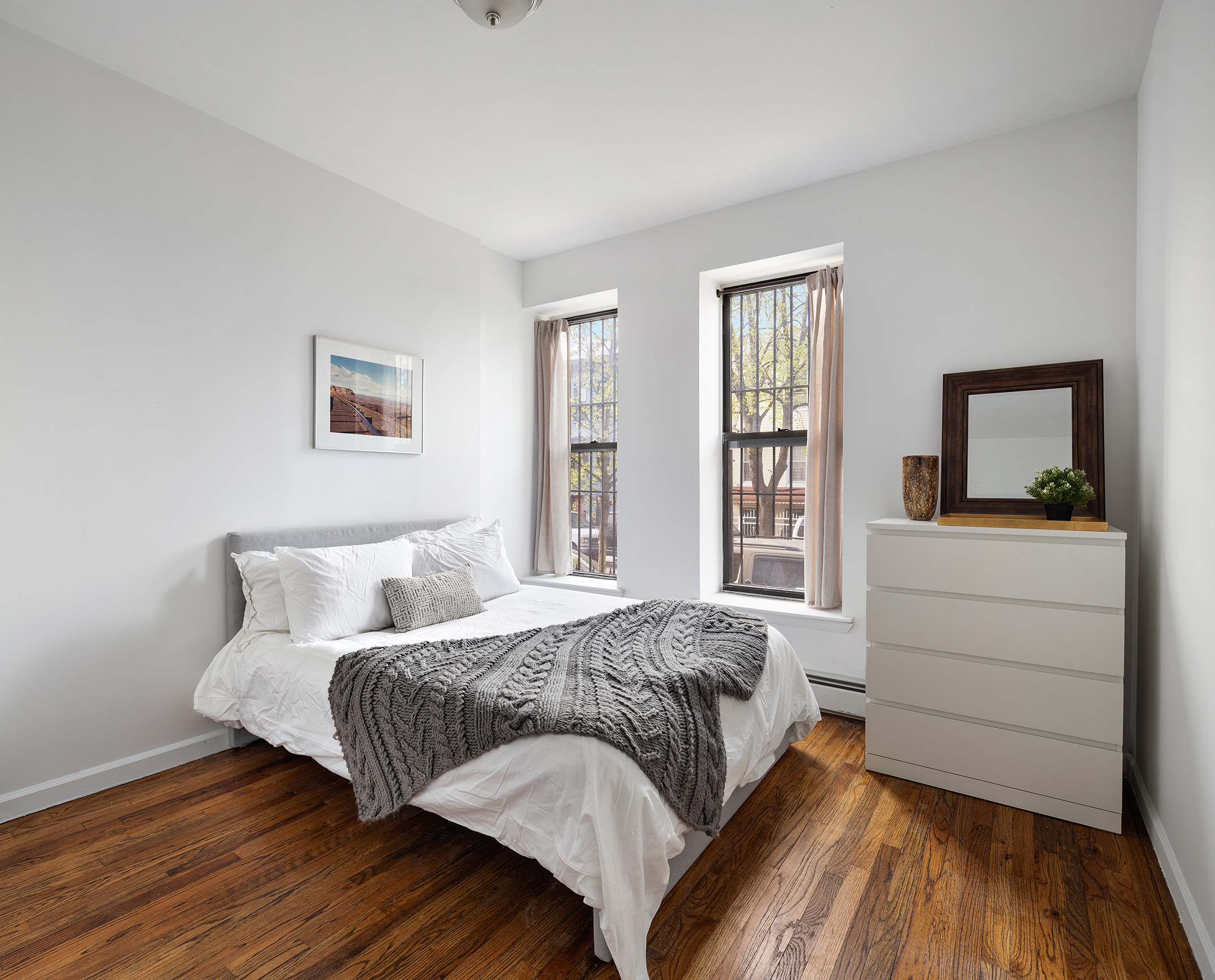 246 Sumpter Street, Unit 1C Brooklyn, NY 11233 - Photo 4 of 12 a bedroom with a bed and a large window