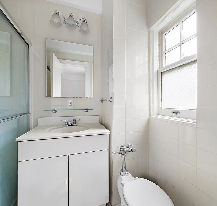 250 West 94th Street, Unit 5D Manhattan, NY 10025 - Photo 16 of 17 a bathroom with a toilet sink vanity and mirror