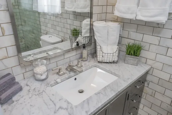a bathroom with a granite countertop sink a toilet and shower
