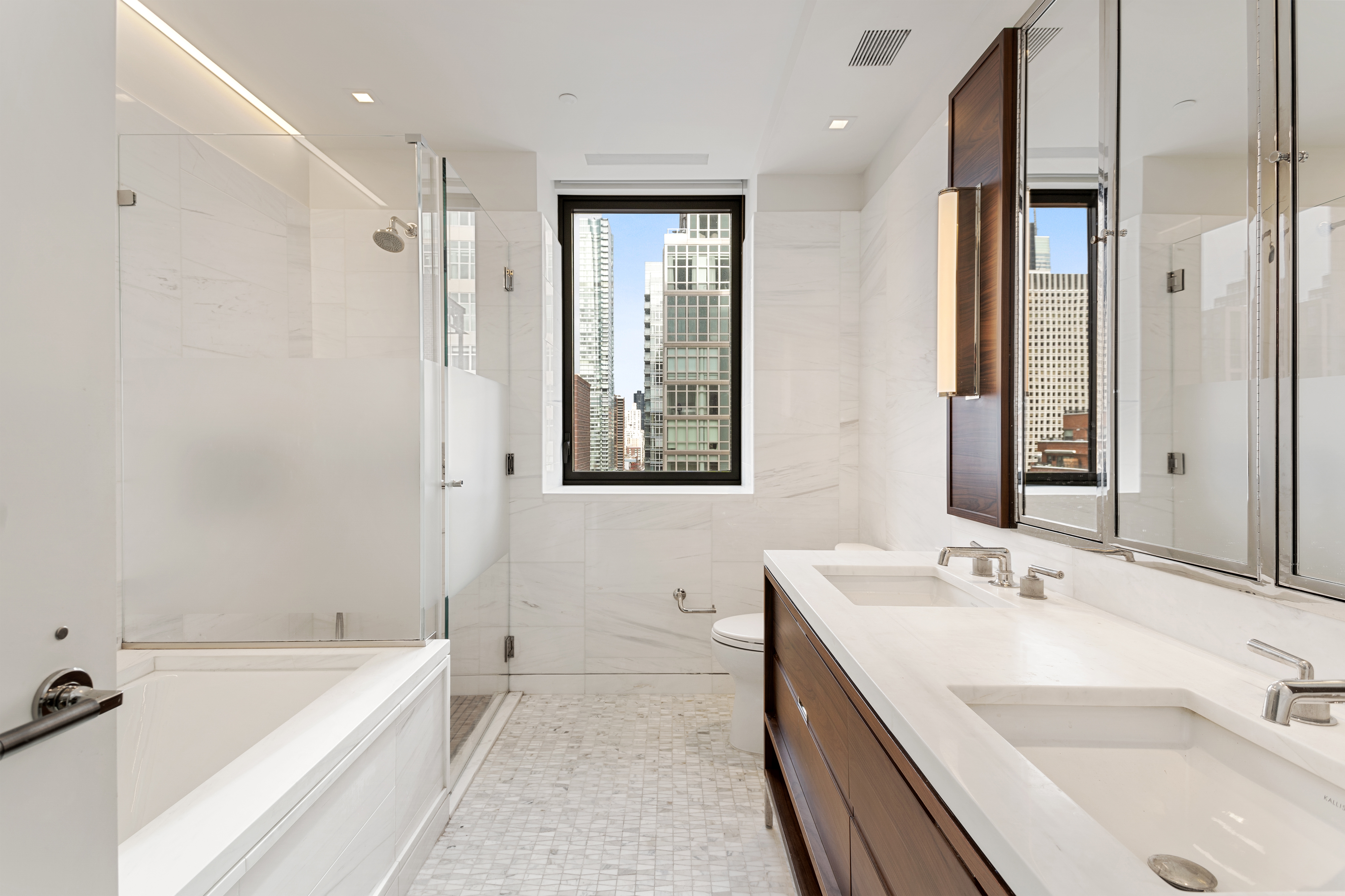 301 East 50th Street, Unit 17B Manhattan, NY 10022 - Photo 3 of 12 a bathroom with a tub a sink and mirror