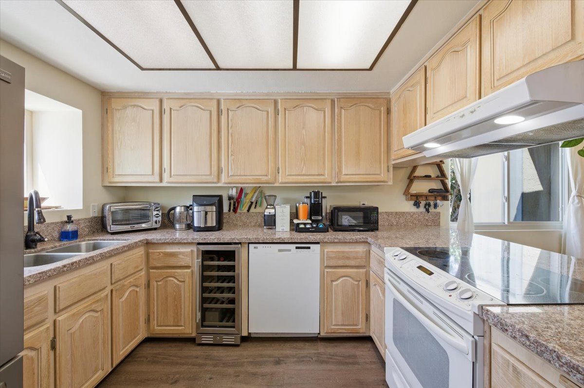 6373 Rancho Mission Road, Unit 5 San Diego, CA 92108 - Photo 4 of 30 a kitchen with white cabinets and white appliances
