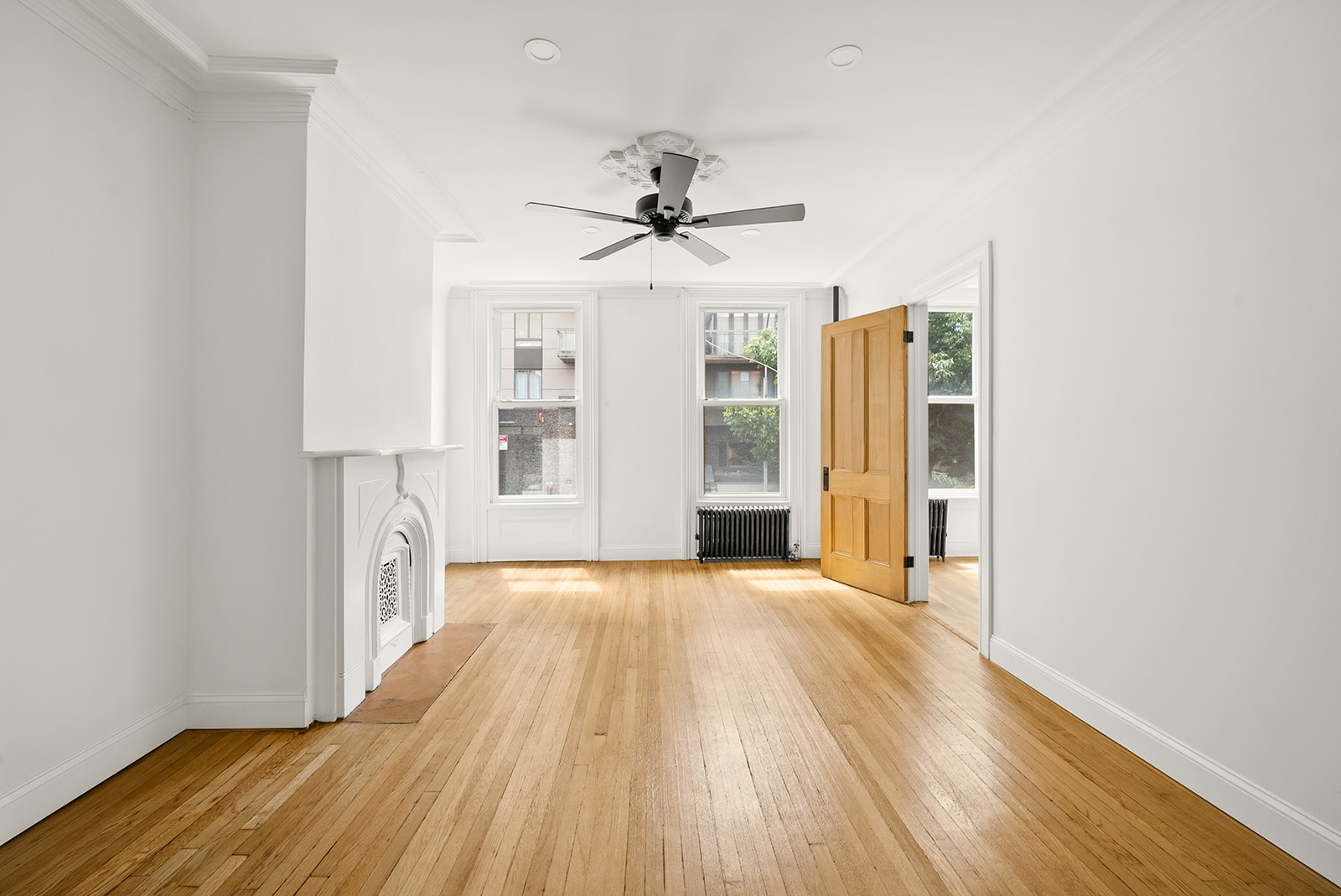 211 12th Street, Unit 2 Brooklyn, NY 11215 - Photo 1 of 7 a view of a big room with wooden floor a ceiling fan and windows