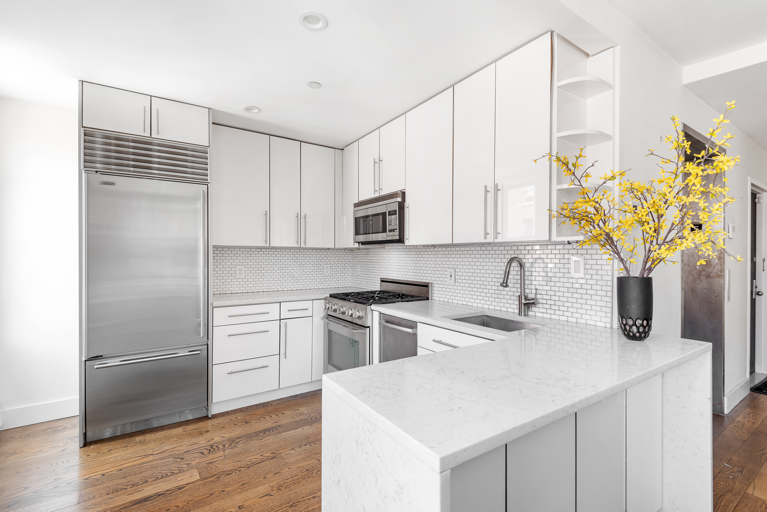 176 Mulberry Street, Unit 5 Manhattan, NY 10013 - Photo 5 of 12 a kitchen with stainless steel appliances granite countertop a sink a stove and a refrigerator