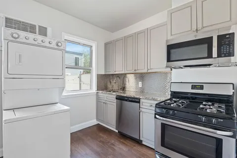 a kitchen with white cabinets and appliances