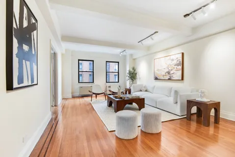 a living room with furniture a table and wooden floor