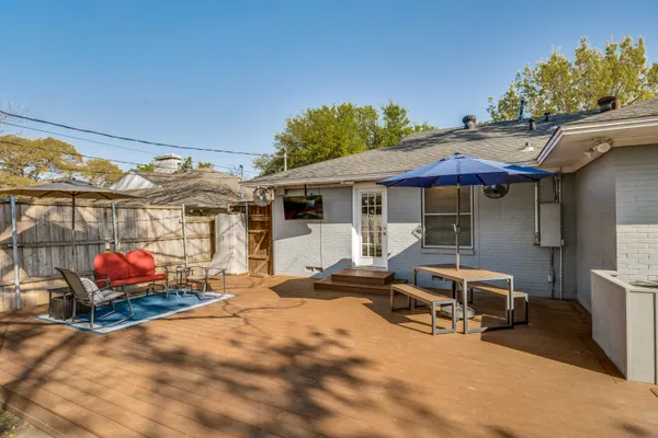 a view of a patio with table and chairs under an umbrella