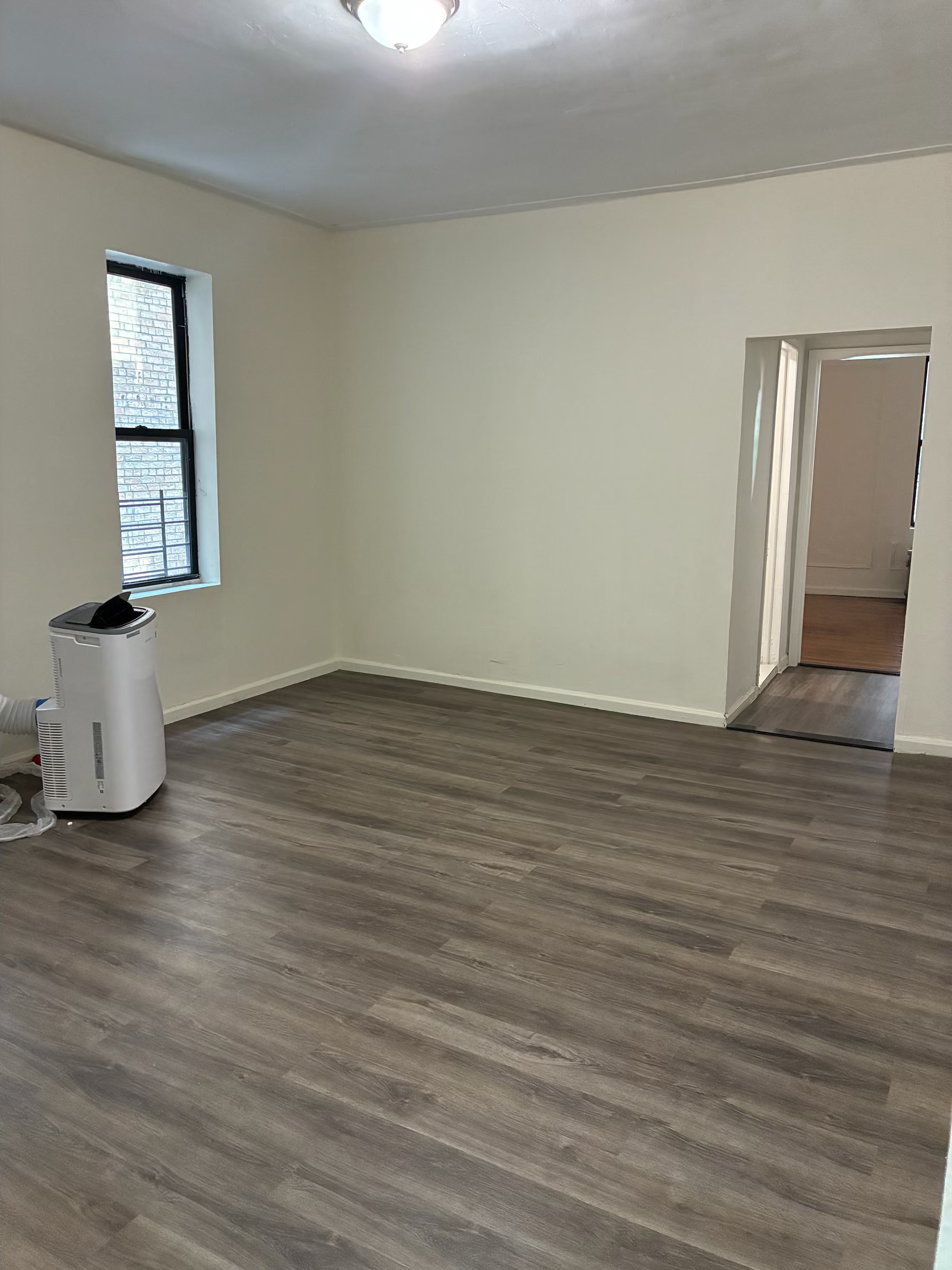 2755 Reservoir Avenue, Unit 1F Bronx, NY 10468 - Photo 1 of 5 a view of an empty room with wooden floor and a window