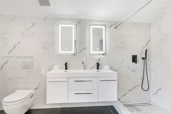 a bathroom with a sink toilet vanity and shower