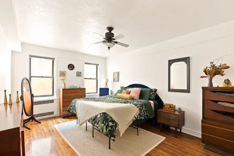 a living room with furniture two large windows and a chandelier