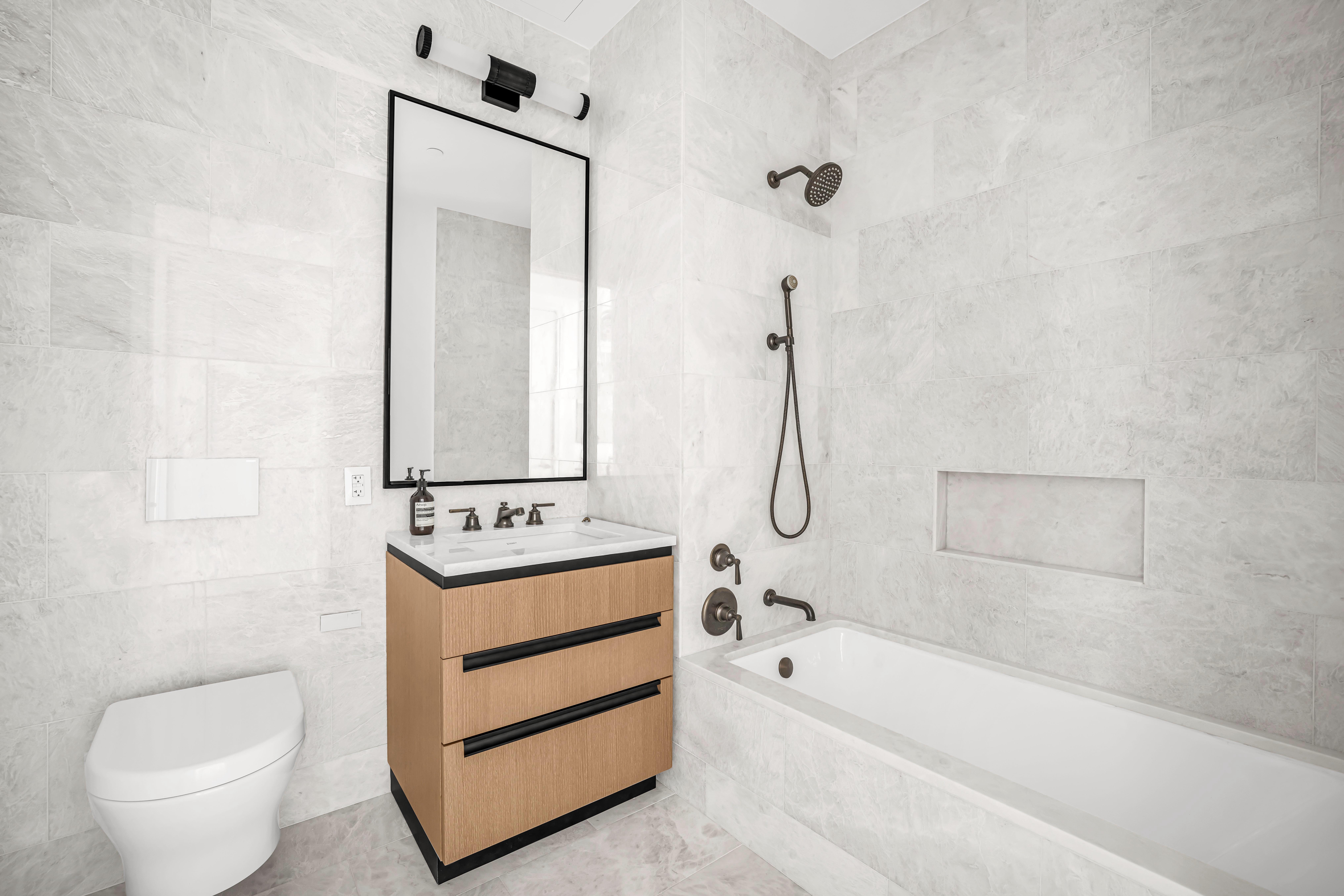 515 West 18th Street, Unit 1504 Manhattan, NY 10011 - Photo 7 of 11 a bathroom with a sink a toilet and bathtub
